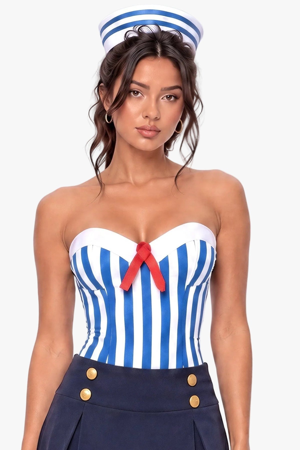 A woman modeling a sailor-themed costume set featuring a blue and white striped strapless corset top with a red bow, a navy blue pleated mini skirt with gold buttons and white stripes, and a matching navy blue sailor hat.