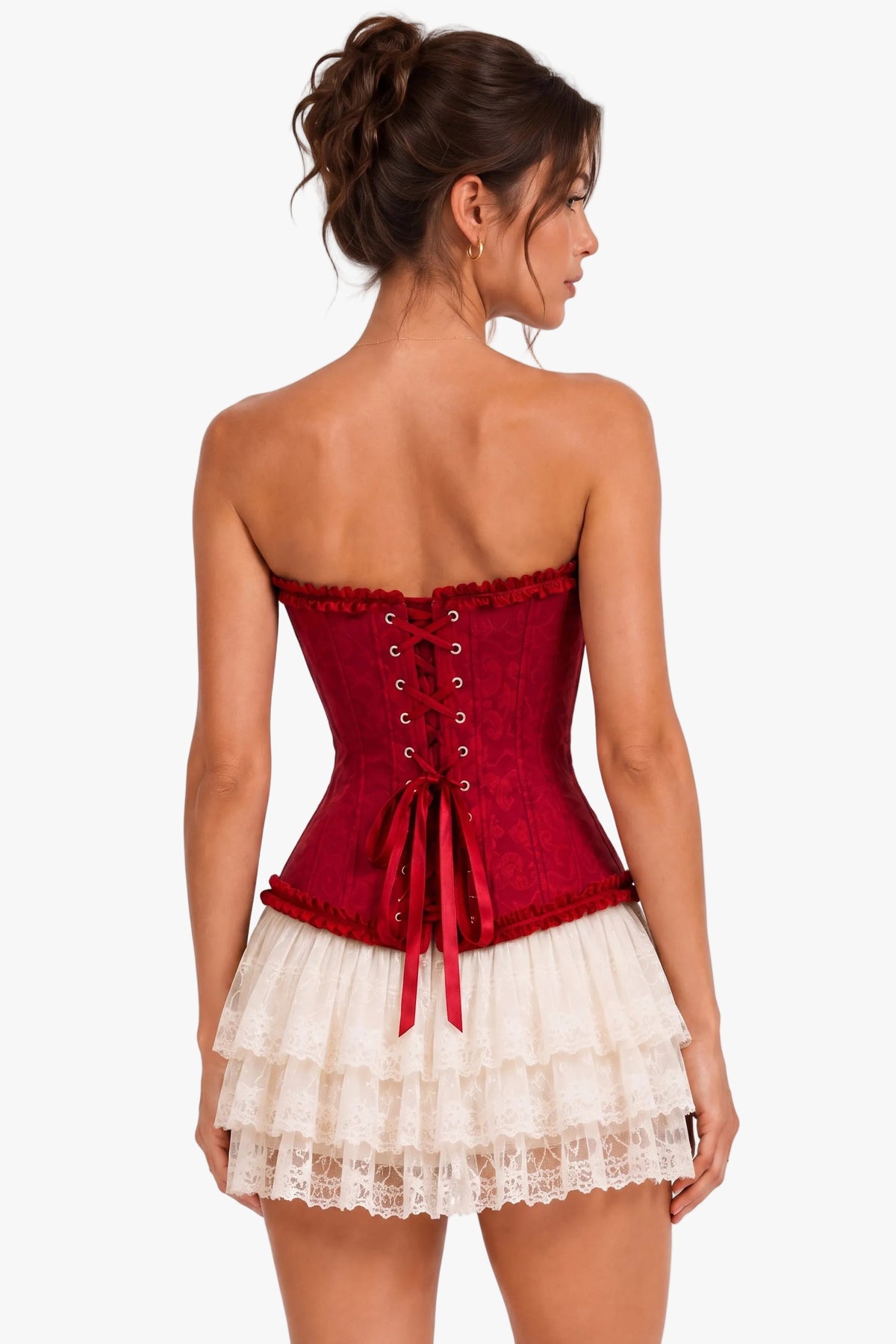 A woman shown from the back wearing a red lace-up corset top with a short cream ruffled skirt, against a plain white studio background.