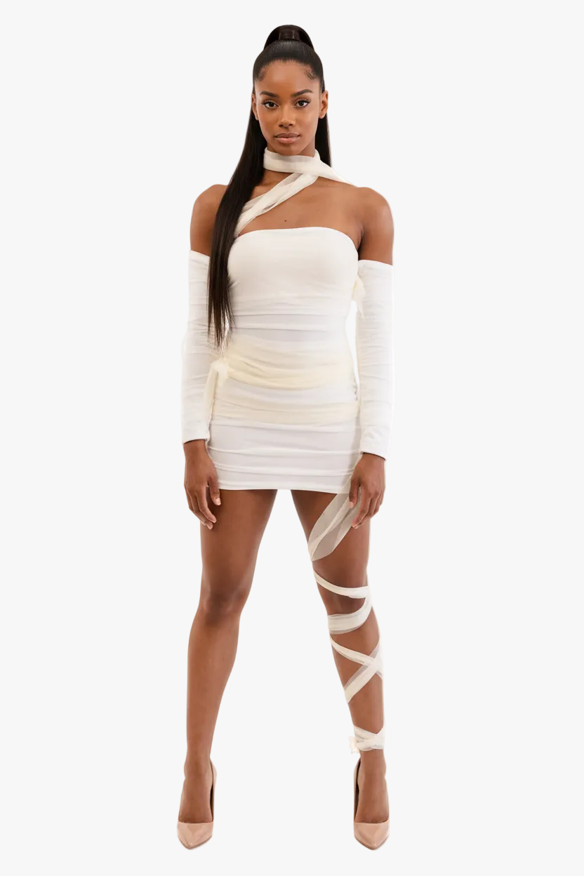 Woman wearing a mummy costume white dress with long sleeves and sheer panels on a white background