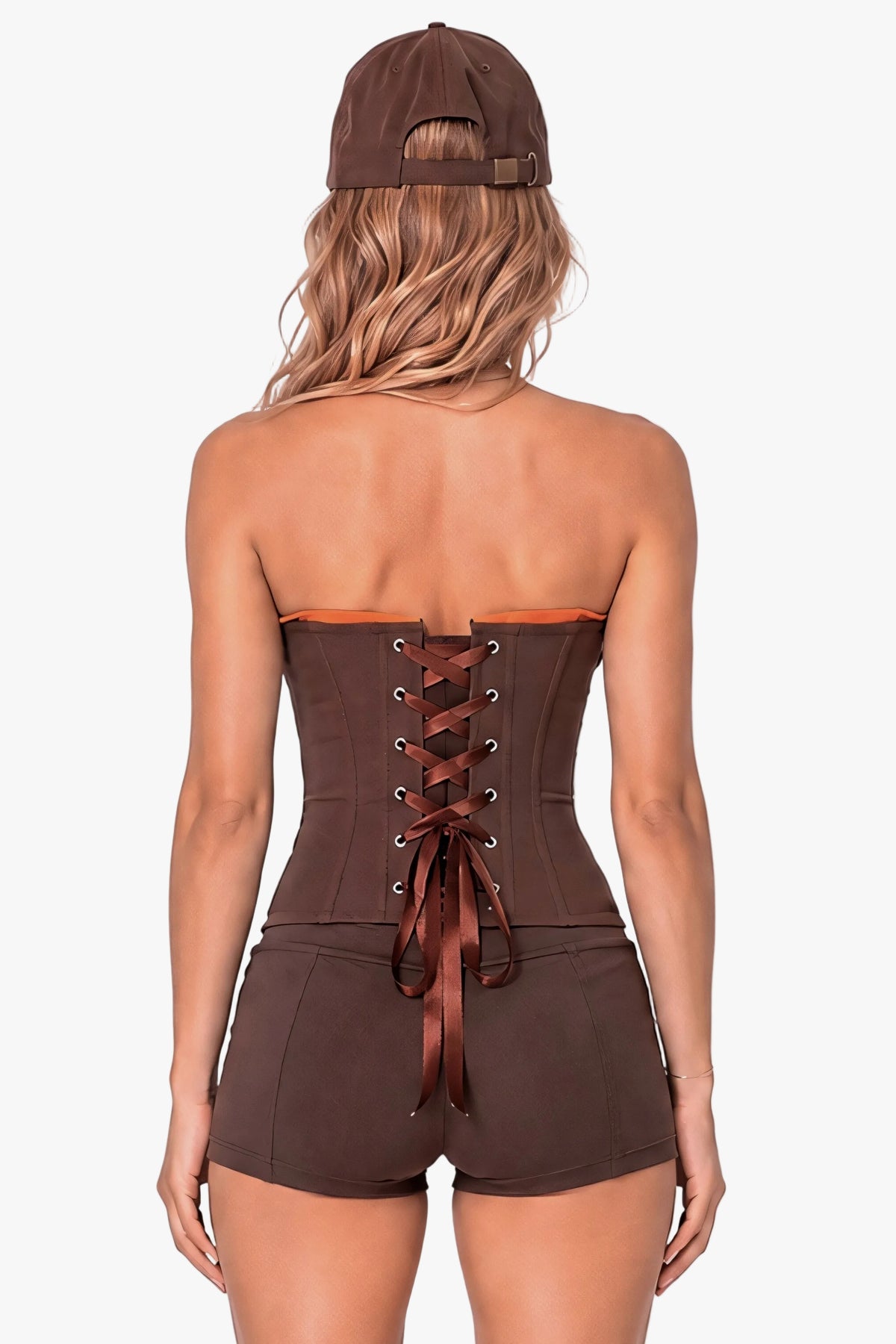 A woman shown from the back wearing a brown strapless corset-style top with lace-up back detail and matching brown shorts, along with a brown baseball cap, against a plain light background.