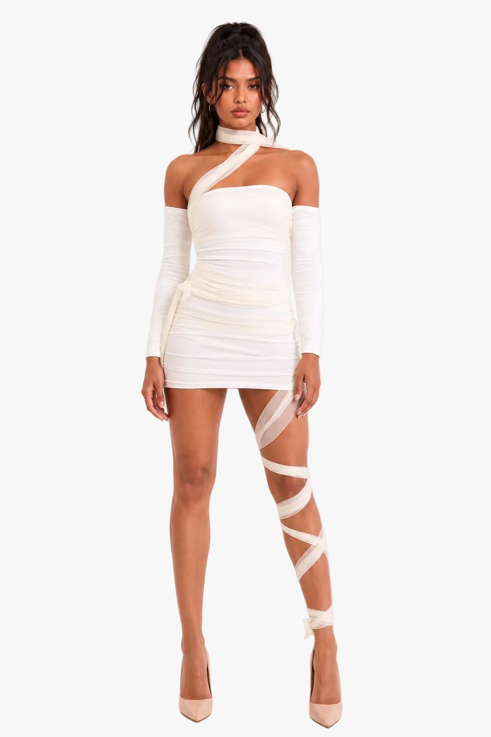A model wearing a white off-the-shoulder mummy costume mini dress with long sleeves, wrapped in sheer white leg wraps, and nude high heels, set against a plain white studio background.