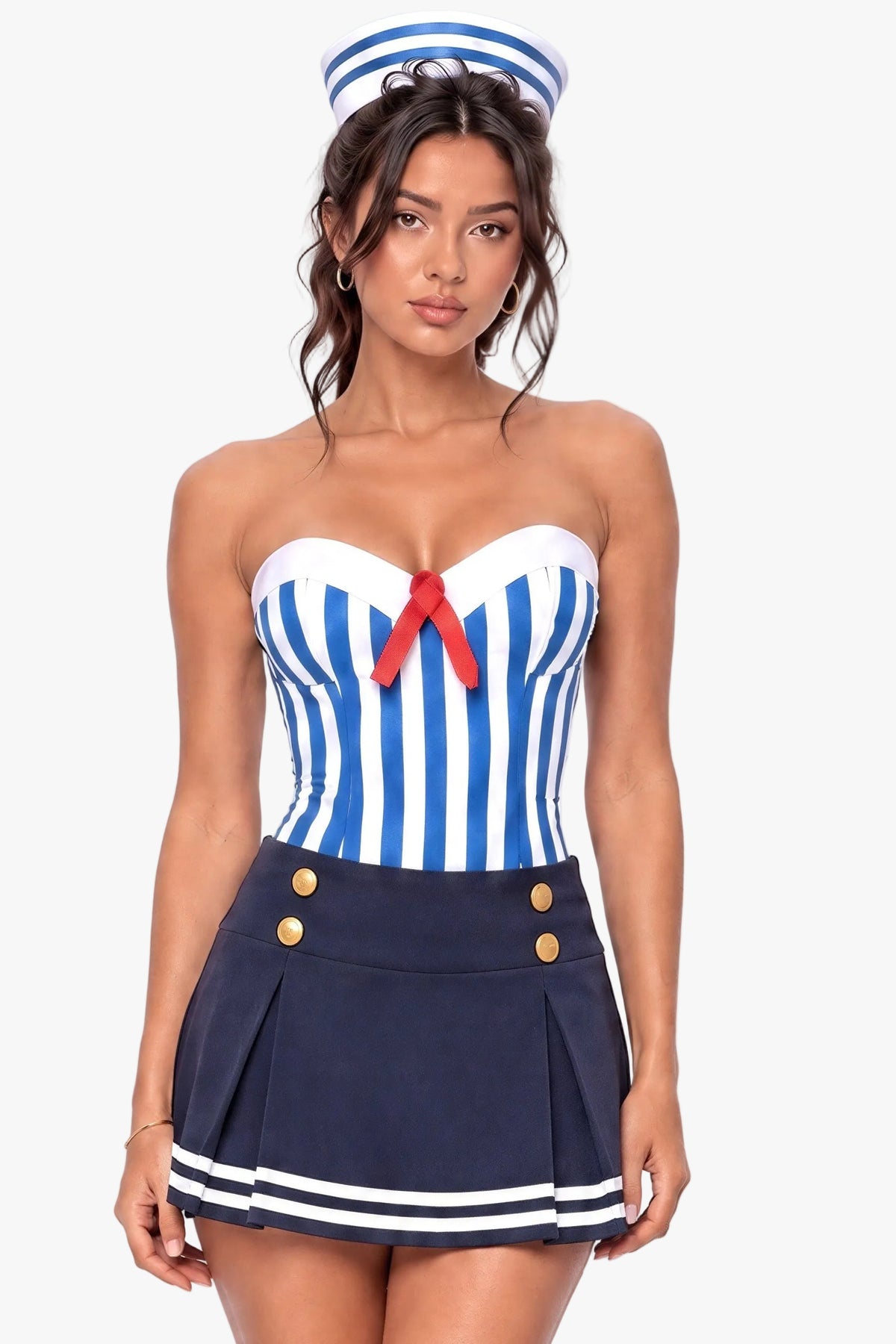 A woman modeling a sailor-themed costume set featuring a blue and white striped strapless corset top with a red bow, a navy blue pleated mini skirt with gold buttons and white stripes, and a matching navy blue sailor hat.