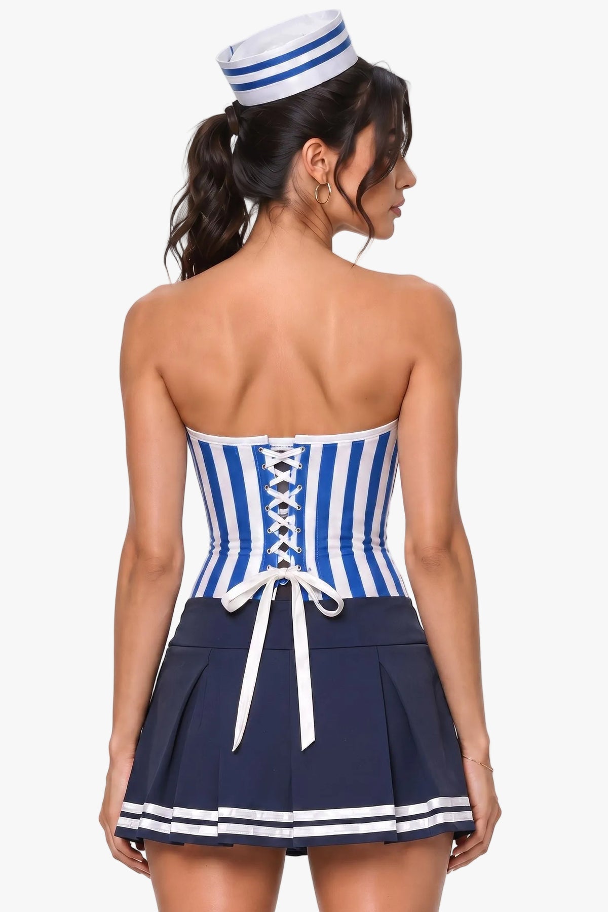 A woman shown from the back wearing a sailor-inspired costume corset with a blue and white striped strapless top, white lace-up back detail, and a navy pleated skirt with white stripes, plus a matching navy-and-white striped hat against a light gray studio background.