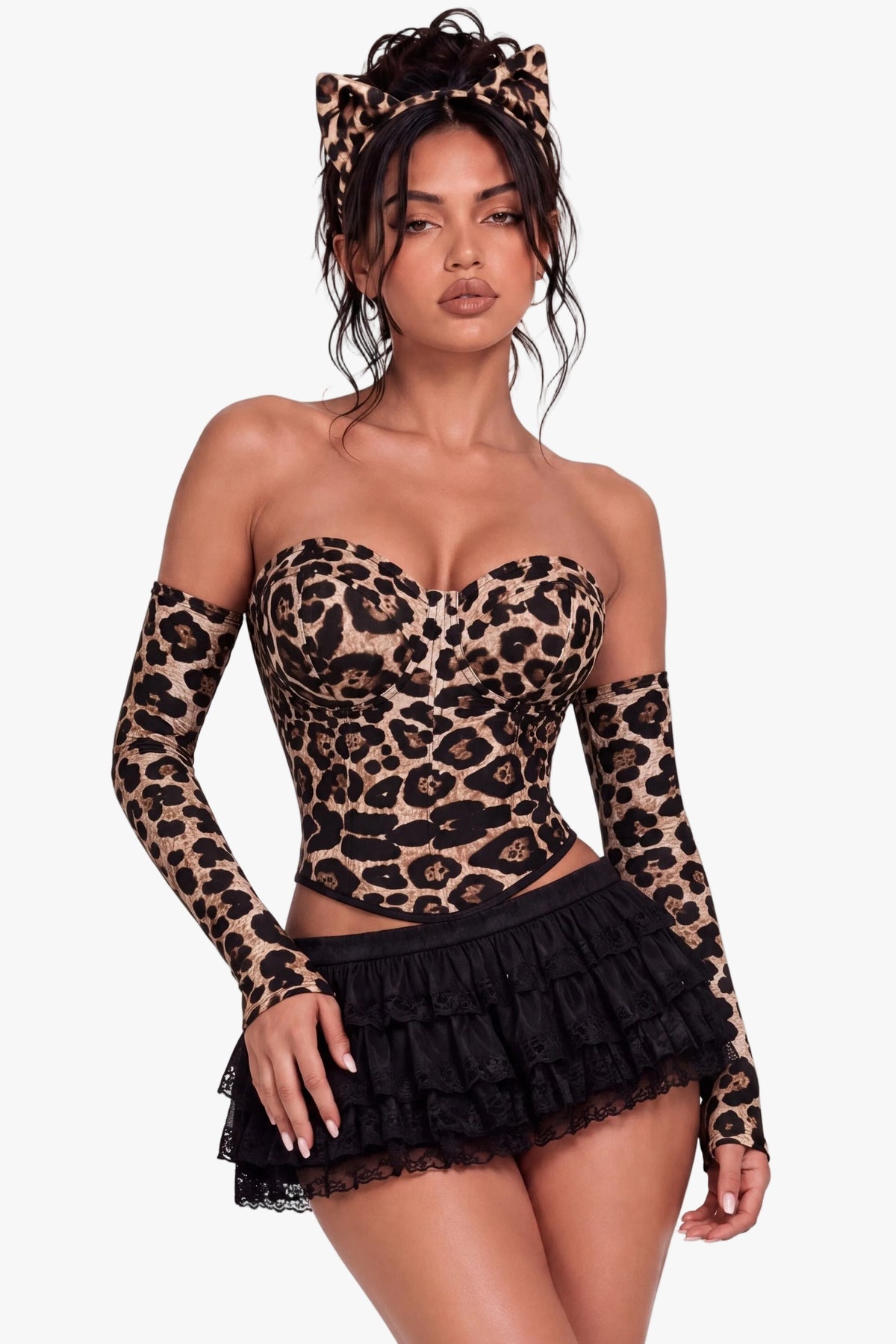 A woman modeling a leopard-print long-sleeve strapless top with matching leopard-print headband, paired with a black ruffled mini skirt, against a plain white background.