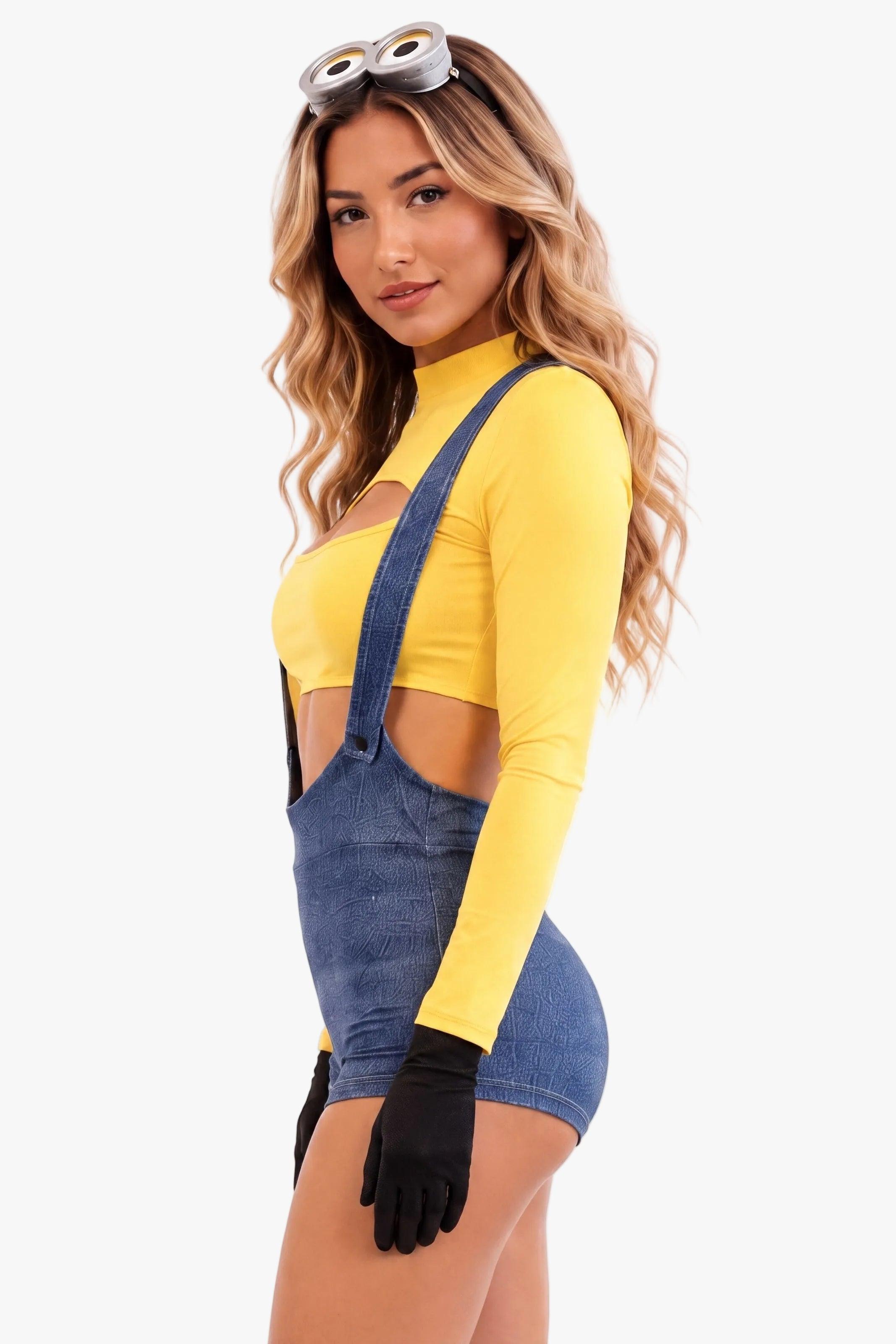 A woman modeling a minion costume - yellow long-sleeve crop top with side cutouts, paired with blue denim-style suspenders, black gloves, and goggles on a headband, against a plain white background.