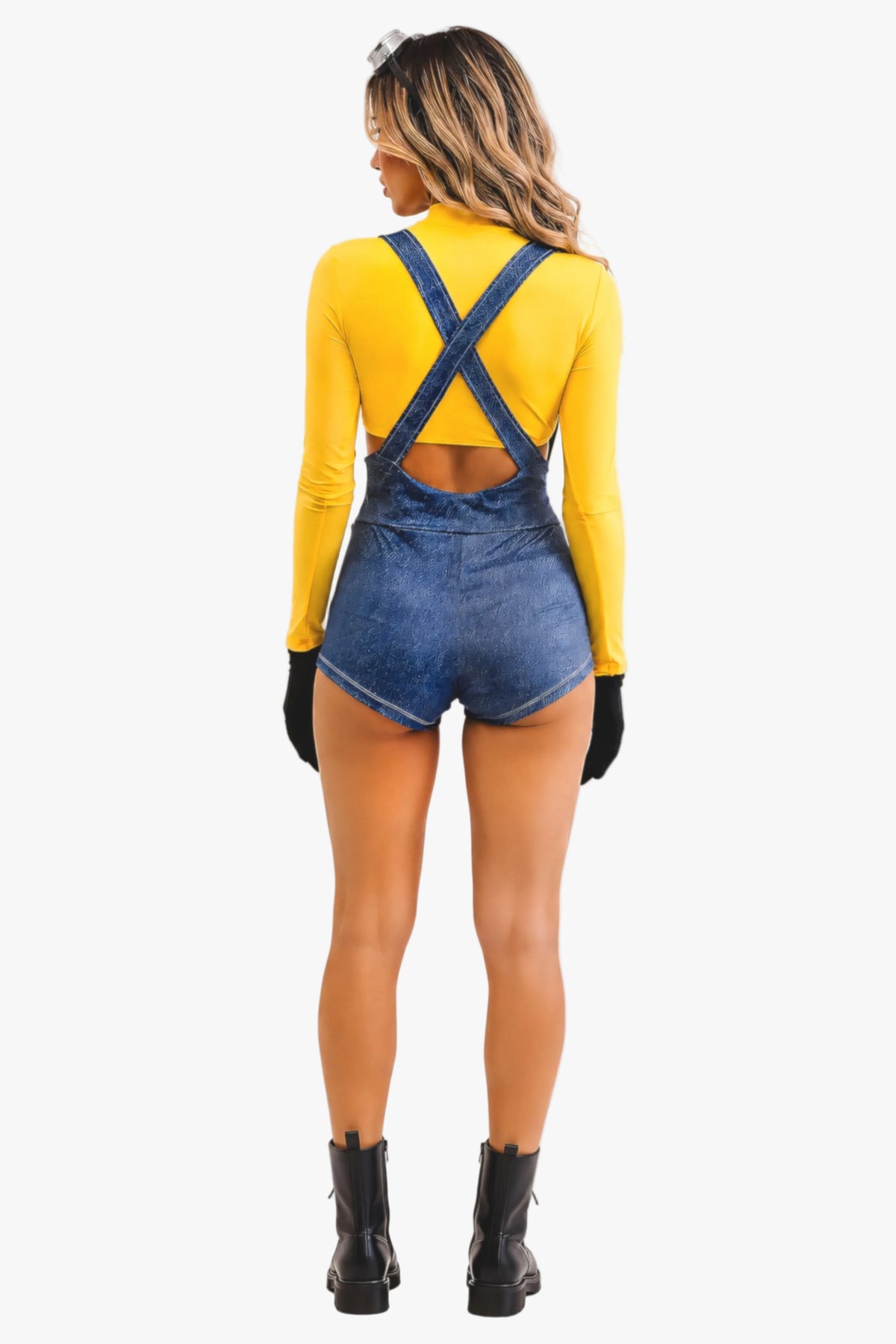 A woman shown from the back wearing a minion costume - a yellow long-sleeve top and blue denim overalls with crossed back straps, black gloves, and black ankle boots against a plain white background.