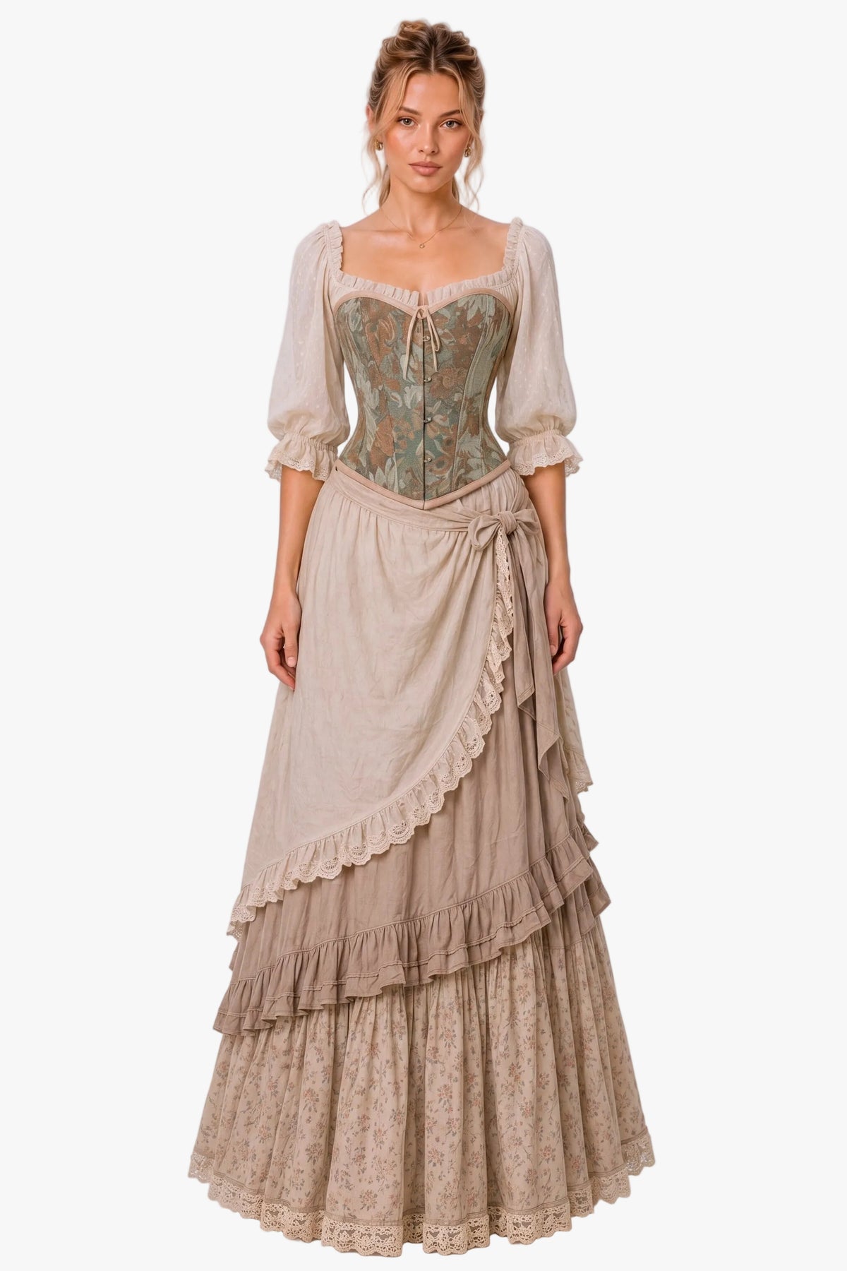 A woman modeling a long Victorian-style dress with a beige tiered skirt, lace trim, and a fitted bodice featuring green and gold floral embroidery, set against a plain light gray studio background.