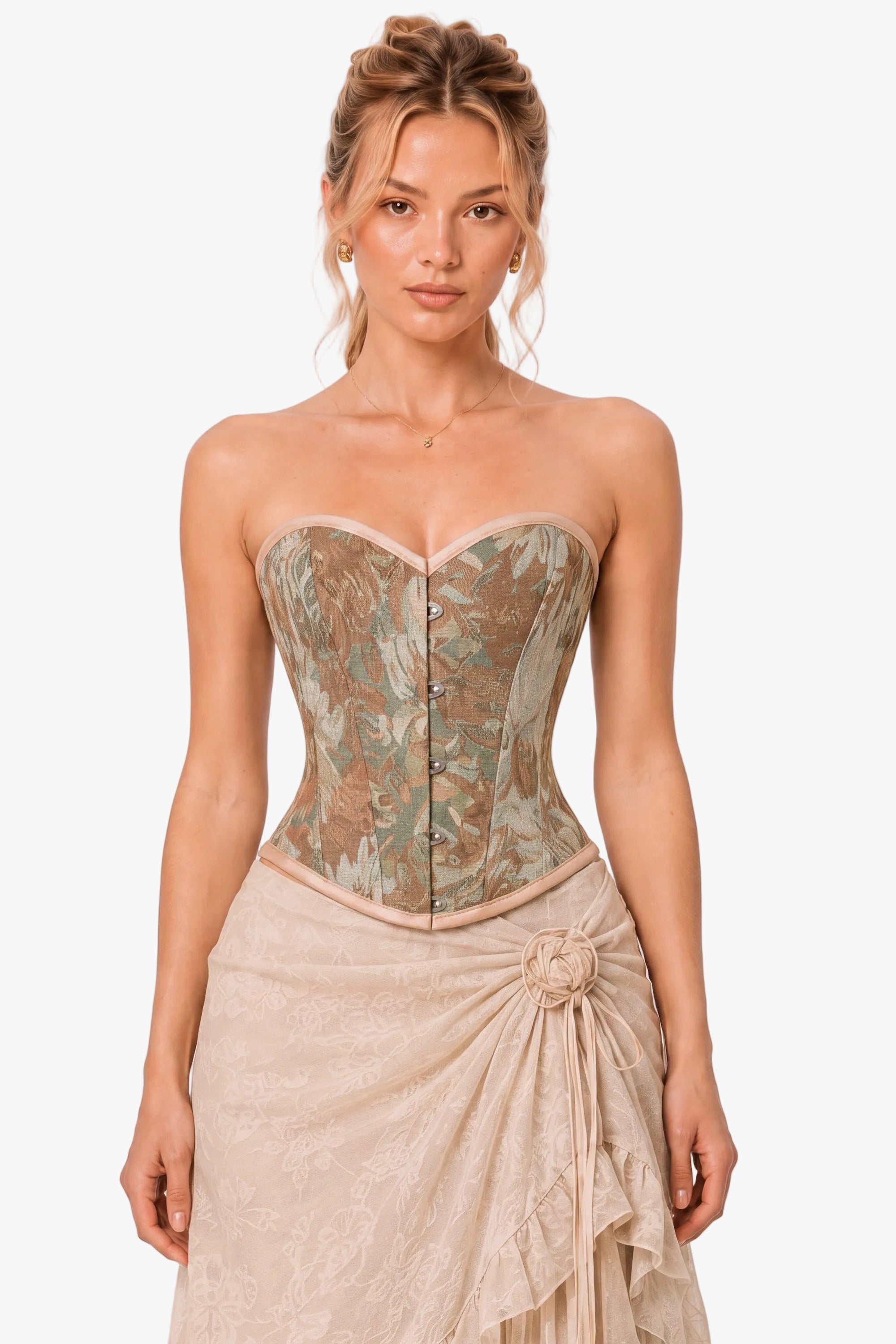 A woman modeling a strapless corset top with a muted floral pattern in beige, brown, and sage green, paired with a matching beige skirt against a light gray studio background.