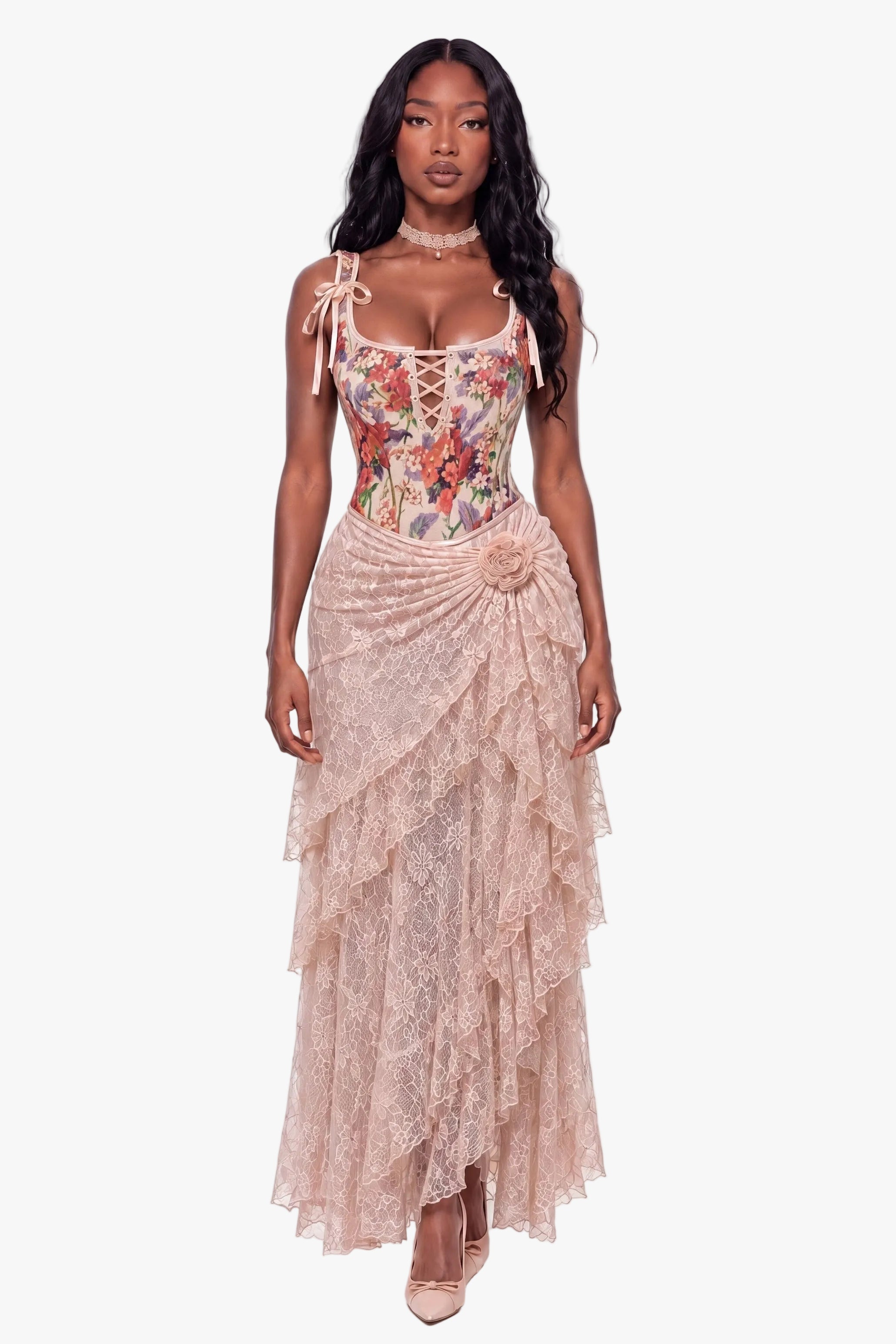 A model wearing a two-piece formal gown set consisting of a floral lace corset top with tie straps and a matching tiered lace skirt in a dusty rose color, shot against a solid white studio background.