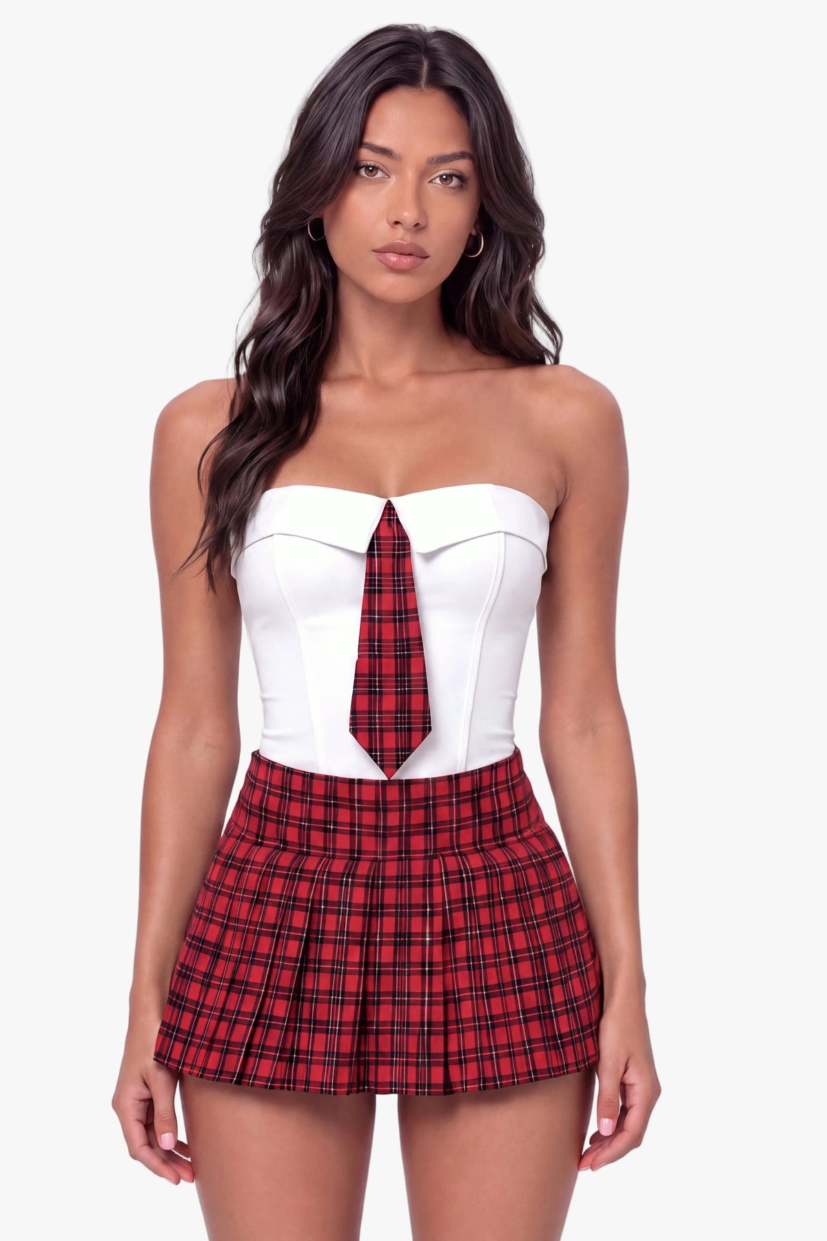 A woman modeling a schoolgirl strapless white corset top with a red and black plaid tie detail, paired with matching red and black plaid pleated mini shorts and black high heels, against a plain white studio background.