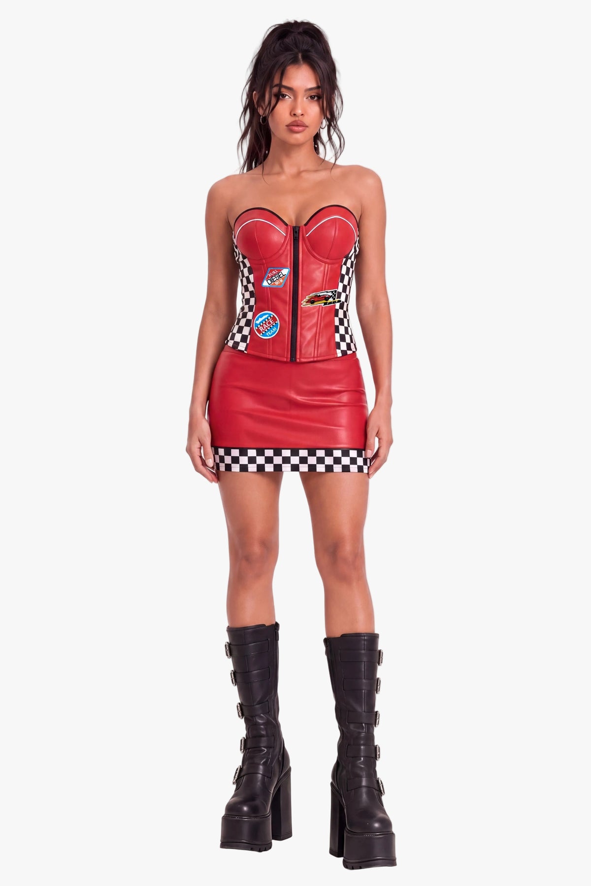 A model wearing a red faux leather racing-themed sweetheart corset-style top, black and white checkered side panels, and racing patch details, with matching mini skirt, set against a plain white studio background.